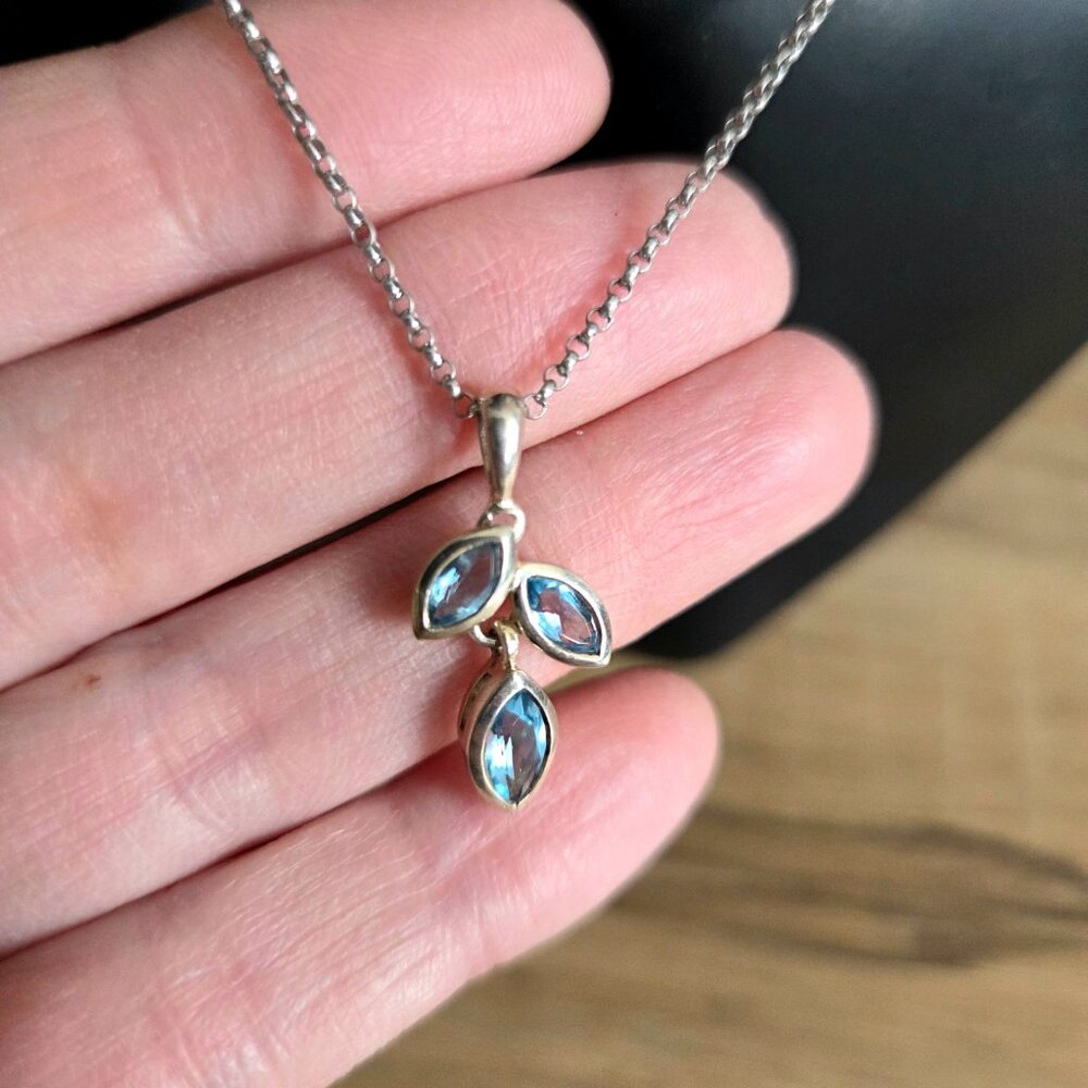 Sterling silver dangling pendant with blue stones leaves shape.